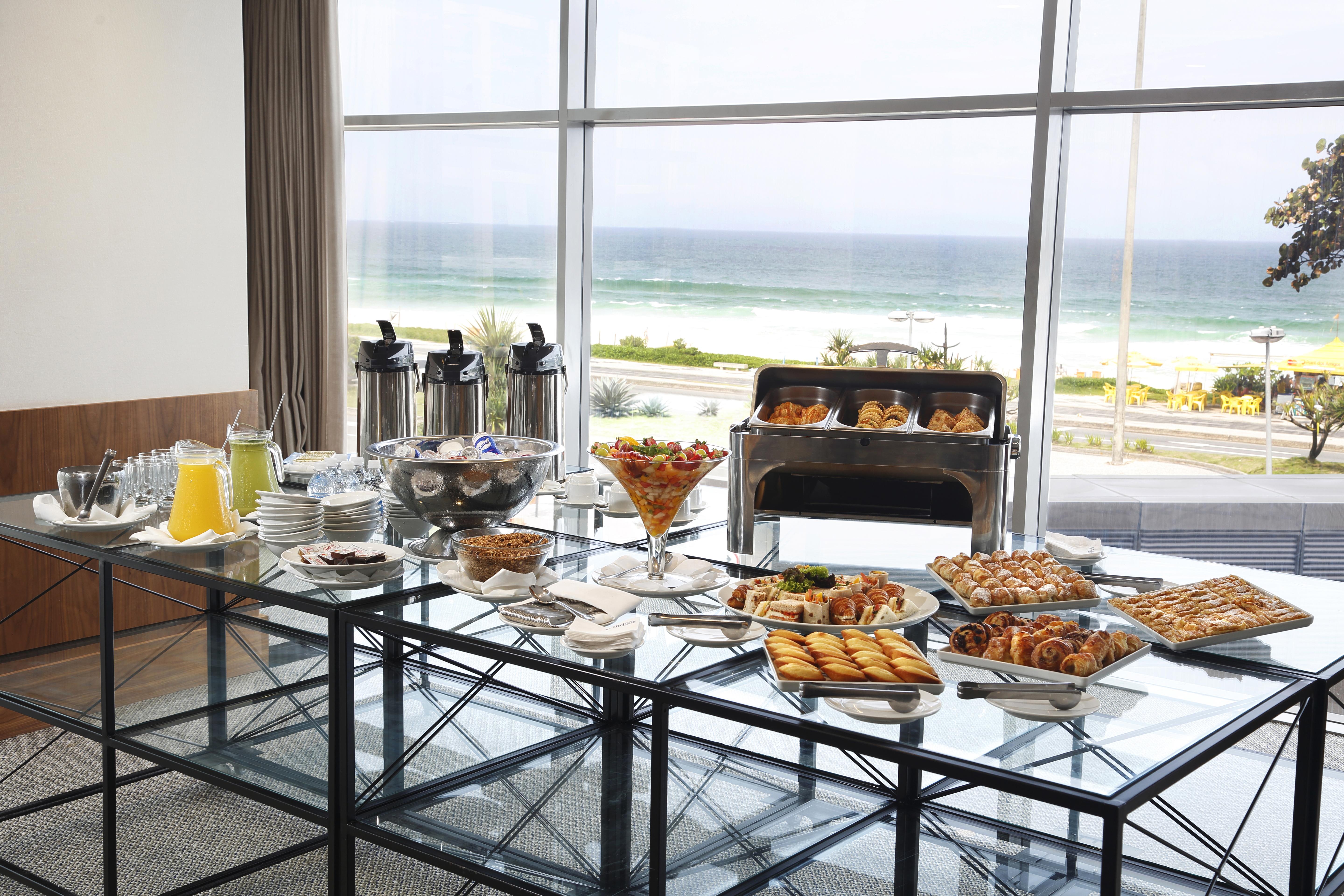 Windsor Marapendi Hotel Rio de Janeiro Bagian luar foto The photo shows a beautifully arranged buffet table with a variety of food items. In the foreground, there are multiple plates and bowls filled with different dishes, including pastries, fruits, and savory items. There are also drinks available, such